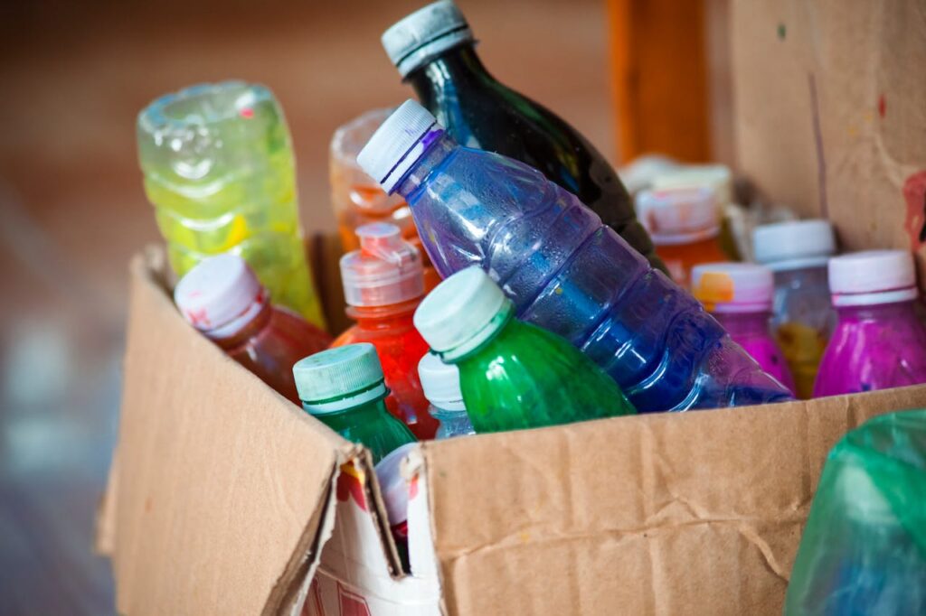 Educação Ambiental: Formando Gerações Conscientes - Foto de Phong Võ: https://www.pexels.com/pt-br/foto/garrafas-plasticas-coloridas-em-caixa-de-papelao-29484316/