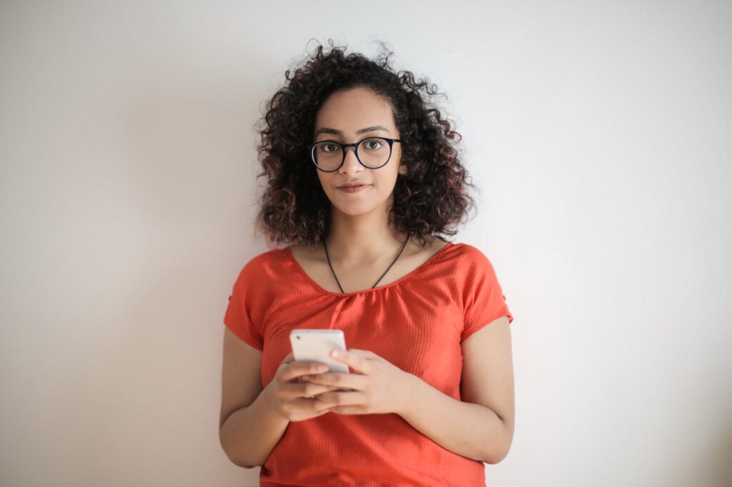 Os Fatores Ocultos no Emagrecimento | Foto de Andrea Piacquadio: https://www.pexels.com/pt-br/foto/foto-de-mulher-com-blusa-vermelha-e-oculos-de-armacao-preta-segurando-um-smartphone-branco-3762370/